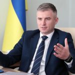 Oleksandr Novikov, il direttore del NAPC seduto alla scrivania, con alle spalle una bandiera dell'Ucraina