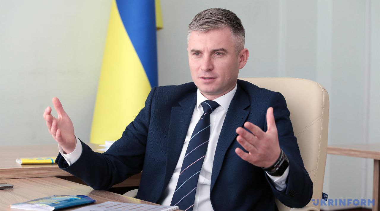 Oleksandr Novikov, il direttore del NAPC seduto alla scrivania, con alle spalle una bandiera dell'Ucraina