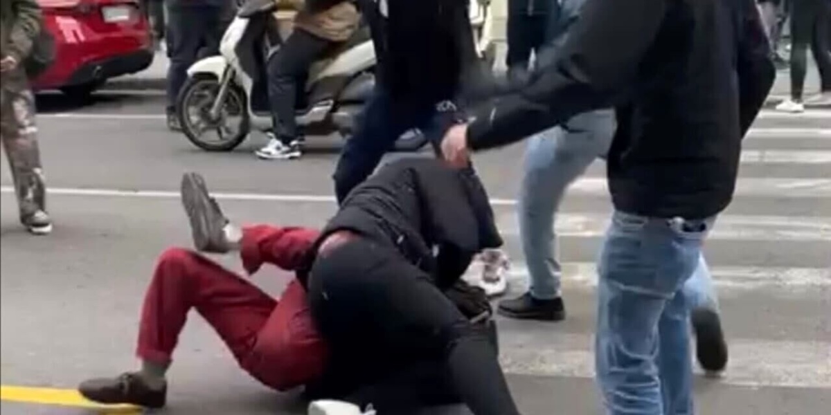 un frame dell'aggressione di sabato di fronte al liceo Michelangiolo. uno studente per terra è circondato da due militanti, con uno che gli sta sopra per tenerlo fermo
