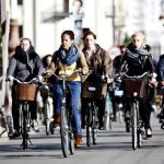 persone in bicicletta su una pista ciclabile in una città europea