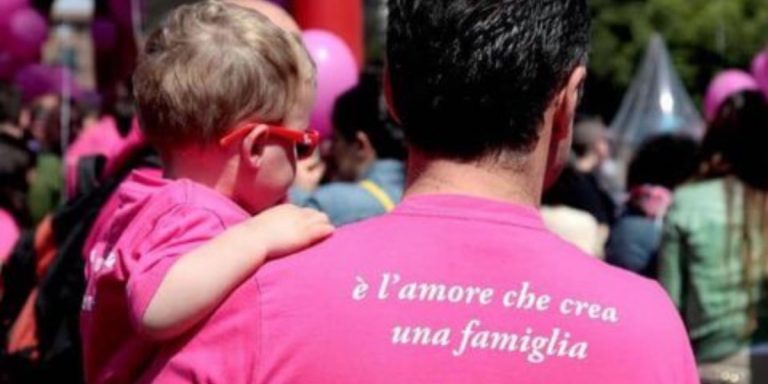 Un papà e un figlio al pride manifestano per le famiglie arcobaleno.