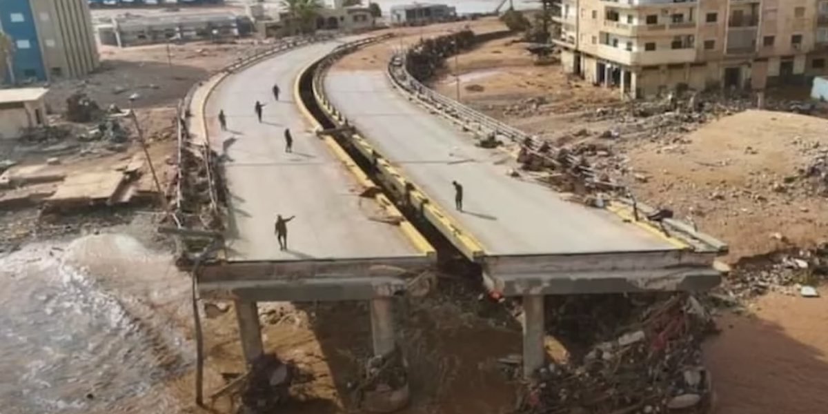 Alcuni operai osservano i resti di un ponte distrutto dalle inondazioni in Libia. Marocco e Libia stanno fronteggiando le conseguenze di due calamità naturali.