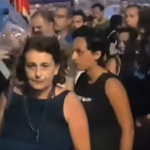 La giudice Iolanda Apostolico davanti a dei manifestanti. Di spalle, davanti a lei, si vede il casco di un poliziotto schierato in un cordone