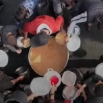 Immagine dall'alto che mostra un gruppo di civili attorno a una pentola per prendere una razione. Il rapporto di Human Rights Watch documenta come Israele abbia impedito l'accesso a cibo e acqua, affamando la popolazione civile a Gaza.