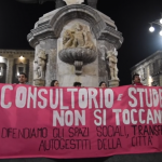 Manifestanti in piazza con lo striscione che recita: "consultorio e studentato non si toccano - difendiamo gli spazi sociali, transfemministi autogestiti della città"