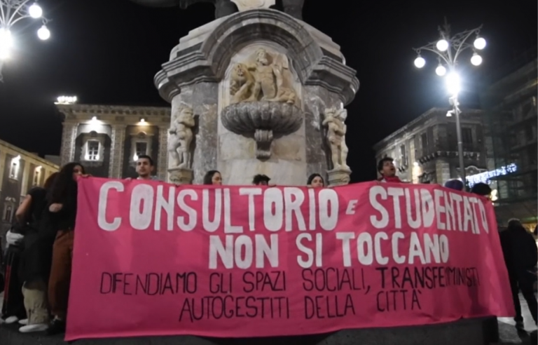 Manifestanti in piazza con lo striscione che recita: "consultorio e studentato non si toccano - difendiamo gli spazi sociali, transfemministi autogestiti della città"