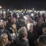 Una folla di manifestanti a Belgrado, in Serbia, solleva i cellulari in modalità "torcia".