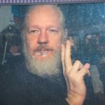 Una foto recente di Julian Assange mentre saluta persone dietro un vetro. Mentre si decide sull'estradizione per Julian Assange, ribadiamo quanto già detto in questi anni: il caso contro il fondatore di Wikileaks minaccia tutti noi.