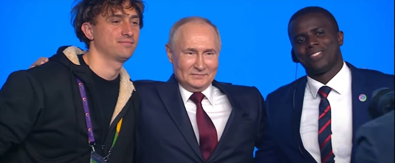Putin in posa, con un braccio sulla spalla di Jorit (alla sua destra). Alla sinistra un altro giovane partecipante all'evento di Sochi
