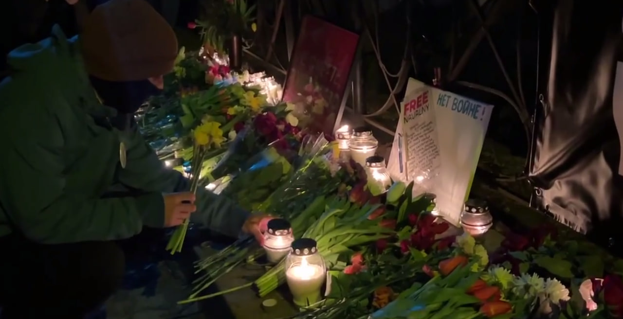 Una donna poggia una candela per il funerale di Navalny.