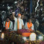 Il premier indiano Modi su un'auto durante la campagna elettorale in India.