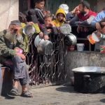 Persone a Gaza attendono cibo con le pentole in mano. La Corte internazionale di giustizia ha emesso ordinanze legalmente vincolanti che impongono a Israele di consentire la fornitura di aiuti umanitari e servizi di base. La Corte lo ha fatto due volte: la prima a gennaio e la seconda a marzo.