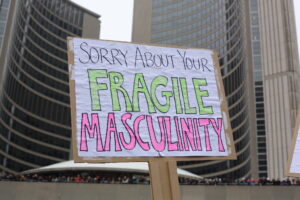 Un cartello di una manifestazione, con scritto "Sorry about your fragile masculinity"