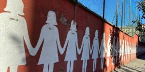 Un murale contro il femminicidio e la violenza di genere lungo il cortile di una scuola