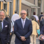 Massimo Adriatici cammina per strada accompagnato dagli avvocati