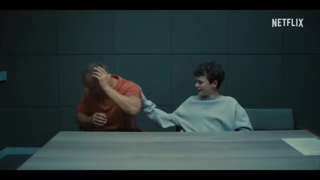 Un bambino in carcere accarezza sul braccio un adulto di spalle che piange