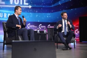 Charlie Kirk seduto accanto a JD Vance durante un evento pubblico