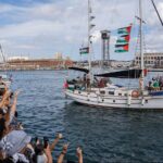 global sumud flotilla, nave che lascia il porto di Barcellona salutata da una folla venuta a sostenerla