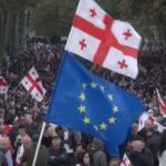Una bandiera delle Georgia e una dell'Unione Europea sventolano durante le proteste contro le elezioni del 5 ottobre