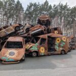 Auto bruciate con girasoli disegnati sui cofani a Buca in Ucraina