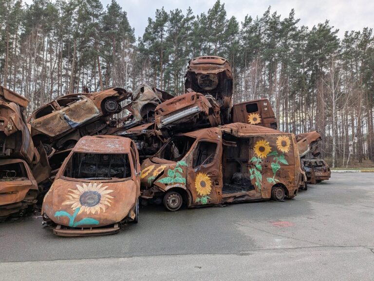 Auto bruciate con girasoli disegnati sui cofani a Buca in Ucraina