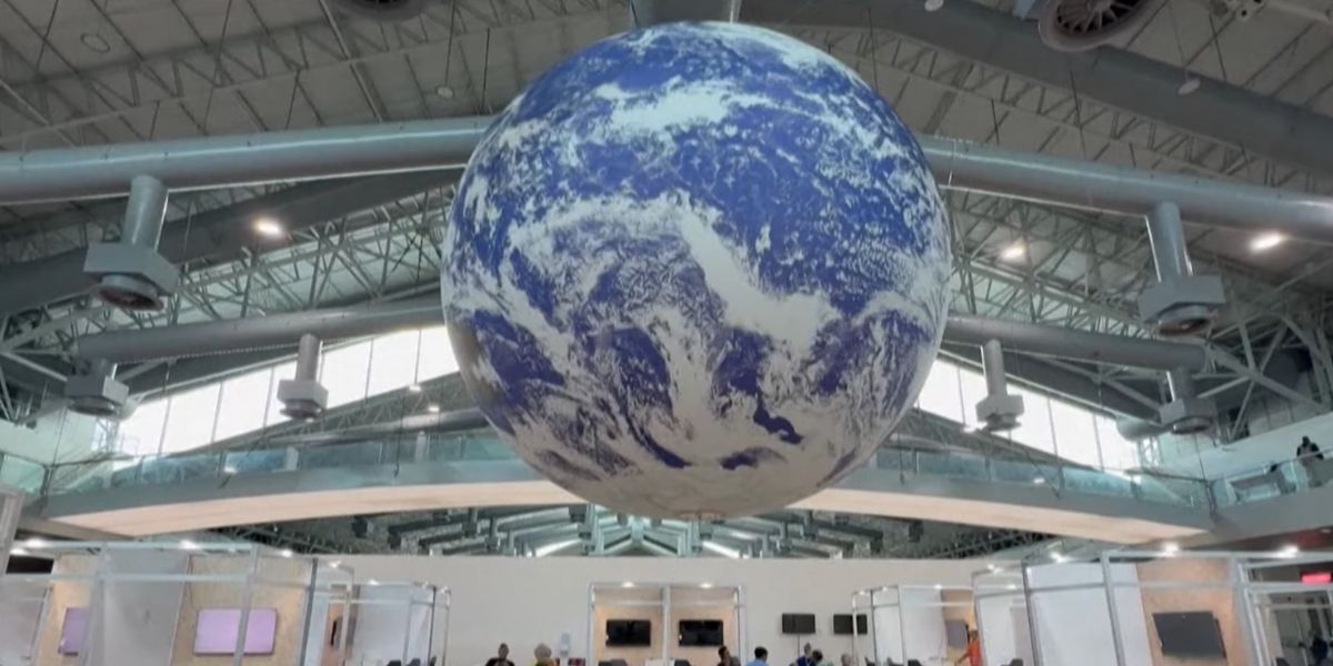 Un grande globo rappresentante il pianeta Terra al centro di una sala per la COP30 in Brasile