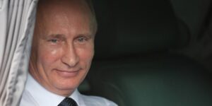 Il presidente della Russia Putin guarda sorridente da una finestra