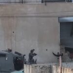 Soldati israeliani con armi puntate contro uomini palestinesi in Cisgiordania