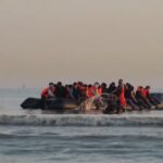 Un gruppo di migranti sbarca su un gommone