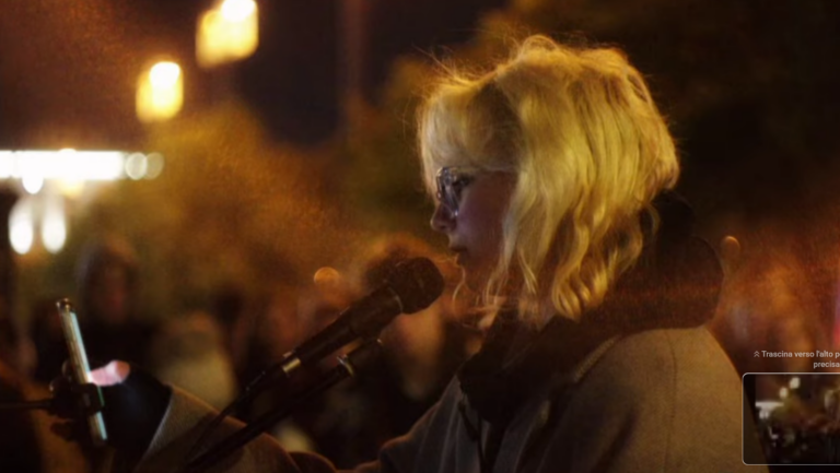 Diana Loginova di profilo davanti al microfono, mentre tiene in mano uno smartphone e si esibisce in pubblico