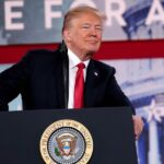 Il presidente USA Trump e dietro la scritta Time for Action